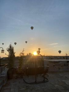 乌奇希萨尔Cappadocia Chiaro的日落时分天空中一组热气球