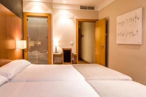 洛格罗尼奥泽尼特洛格罗尼奥酒店的卧室配有白色的床和书桌