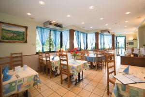 圣阿玛尼米尔巴舍尔客栈的餐厅设有桌椅和蓝色窗帘