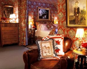 斯托Goldilocks Cabin的一间卧室配有一张床和一把带枕头的椅子