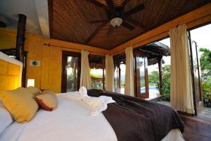 马萨亚庄园天堂之门生态屋水疗度假村的一间卧室配有一张带吊扇的床