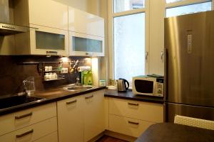 巴登-巴登恩迪特梦公寓的厨房配有白色橱柜和不锈钢冰箱