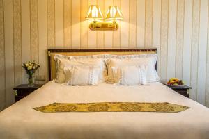 日利纳柏罗姆宫酒店的卧室配有一张带白色床单和枕头的大床。