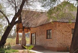 奥马鲁鲁卡沙纳纳米比亚旅馆的茅草屋顶的小砖屋