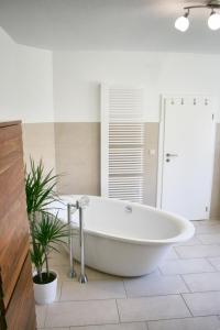 DrewitzFerienhaus Drewitz (EOC-FUP 07/2017)的植物浴室内的白色大浴缸