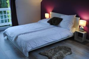 科隆多纳别墅的一间卧室配有一张带两盏灯的大型白色床。