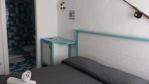 滨海波利尼亚诺卡塞塔佩斯卡托旅馆的一间卧室配有一张床和一张蓝色的桌子