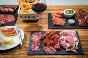 戛纳戛纳中心奥克酒店的一张桌子,上面放着三盘肉和一杯葡萄酒