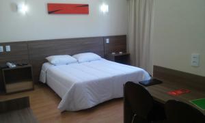 里约热内卢安特拉玛赫斯酒店的卧室配有一张白色大床和一张书桌