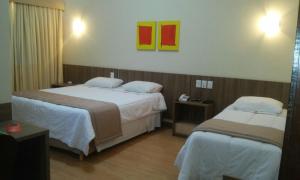 里约热内卢安特拉玛赫斯酒店的酒店客房设有两张床,墙上挂有绘画作品