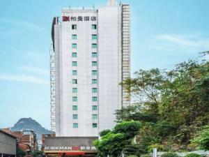 柳州Borrman Hotel Liuzhou Ma'anshan Park Gubu Shopping Mall的一座高大的白色建筑,上面有起重机