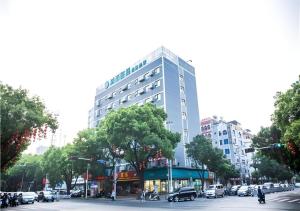 北海City Comfort Inn Beihai Beibu Gulf Golden Beach Underwater World的城市街道上高大的白色建筑,有汽车