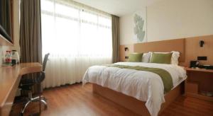 南宁GreenTree Inn Express Guangxi Nanning Mingyang Avenue Nanning Airport的一间卧室配有一张床、一张书桌和一个窗户。