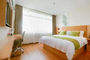 南宁GreenTree Inn Express Guangxi Nanning Mingyang Avenue Nanning Airport的一间卧室配有一张床、一张书桌和一个窗户。