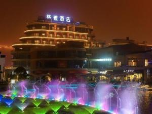 南通Gya Hotel Nantong Nanshang Lake Street Wanda Plaza的建筑物前方有喷泉的建筑物