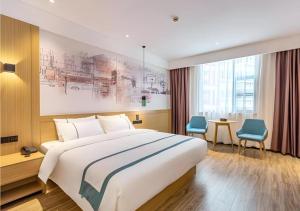 泉州City Comfort Inn Quanzhou Wanda的一间卧室配有一张大床和一张桌子及椅子