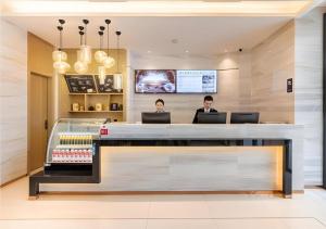 泉州City Comfort Inn Quanzhou Wanda的两个人坐在商店的柜台上