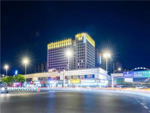 苏州Echarm Hotel Suzhou Shengze Oriental Extile City的一座城市,在晚上有一座带灯光的大建筑