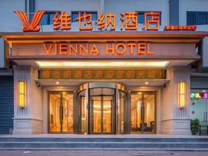 天津Vienna Hotel Tianjin Chentangzhuang Metro Station的文纳酒店前面有 ⁇ 虹灯标志