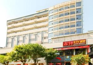 海口City Comfort Inn Haikou Zhongjie Road Walking Street的前面有树木的白色大建筑