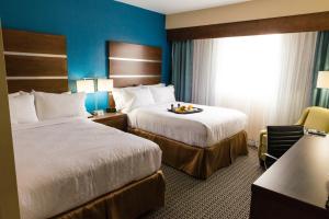 休斯顿休斯顿市中心假日酒店的酒店客房,配有两张床和椅子