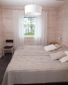 米凯利Ankkuri Raijan Aitta的一间卧室设有一张大床和窗户