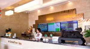 常州GreenTree Inn Changzhou International Airport的站在商店柜台的女人