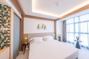 佩里洛Hotel Faranda Rias Altas, Ascend Hotel Collection的卧室设有白色的床和大窗户