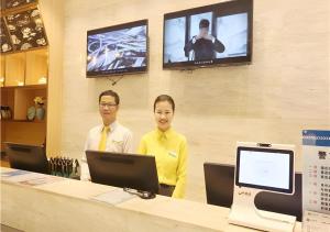 柳州City Comfort Inn Liuzhou Gubu Street Ma'anshan Park的两个男人站在商店的柜台上