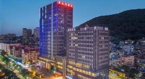 福州Vienna Hotel Fuzhou Mawei的一座高大的建筑,城市里灯火通明