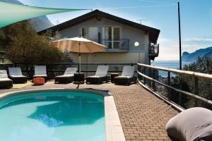 托尔博莱伊索拉豪园酒店的一个带椅子和遮阳伞的游泳池以及一间房屋