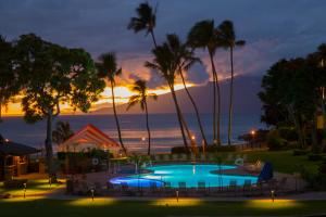 拉海纳纳普里凯海滩度假酒店的棕榈树泳池和日落背景