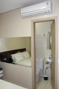 乌贝拉巴Hotel Albatroz的一间卧室配有一张床、一个卫生间和一面镜子