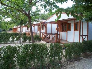 波凯兰特马里奥拉野营简易别墅酒店的白色的房子,有门廊和树