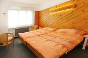 艾因西德伦Allegro Alpin Lodge的一间卧室设有一张大床和木墙
