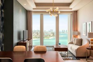 多哈Wyndham Grand Doha West Bay Beach的客厅设有桌子和大窗户