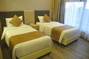 新山吉欧贝酒店的酒店客房设有两张床和窗户。