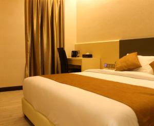 新山吉欧贝酒店的配有一张床和一张书桌的酒店客房