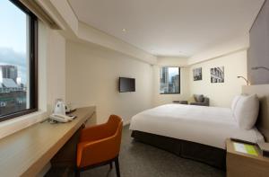 台北老爷会馆台北林森 – 华山文创园区的酒店客房配有一张床、一张书桌和一部电话
