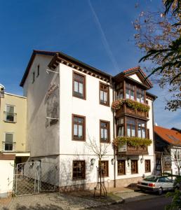 腓特烈罗达Pension Zum-Ratsherrn的白色的建筑,设有窗户和阳台