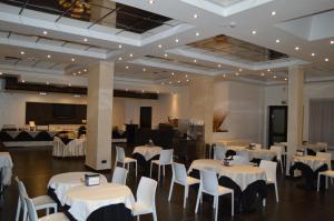 拉奎拉Canadian Hotel的宴会厅配有白色的桌子和白色的椅子