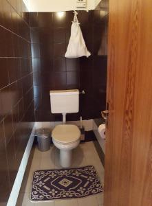 科尔福索Supermountainski Colfosco的一间带卫生间的浴室和黑色瓷砖墙