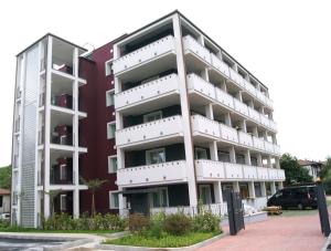 卡萨诺韦马尔彭萨莱西登斯公寓式酒店的停车场内带白色阳台的公寓大楼