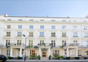 伦敦诺丁山尊贵酒店的大型白色建筑,设有窗户和阳台