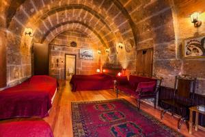 Guzelyurt卡帕多奇亚厄赫拉热峡谷洞穴酒店的一间石墙客房内的卧室,配有两张床