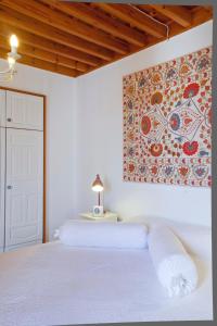 林都斯林都斯别墅度假屋的卧室配有一张白色床,墙上挂有绘画作品
