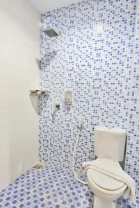 日惹瑞维莎酒店的一间带卫生间的浴室和蓝色瓷砖墙