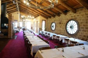 克兰伯恩红木公园汽车旅馆的一间配备有白色桌椅和时钟的餐厅