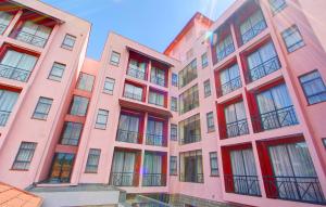 基苏木维多利亚套房酒店的粉红色的公寓楼,设有红色窗户