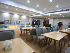 洛阳GreenTree Inn Luoyang Railway Station Wangfujing Wangcheng Park的一间在房间内配有桌椅的餐厅